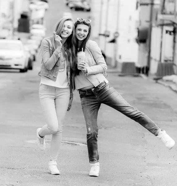 Meninas bonitas hipster namoradas posando com um assento de skate no skate, estilo de vida de rua em óculos de sol — Fotografia de Stock