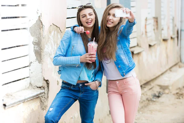 Hipster namoradas tirar uma selfie no contexto urbano da cidade - Conceito de amizade e diversão com novas tendências e tecnologia - Melhores amigos eternizando o momento com smartphone moderno — Fotografia de Stock