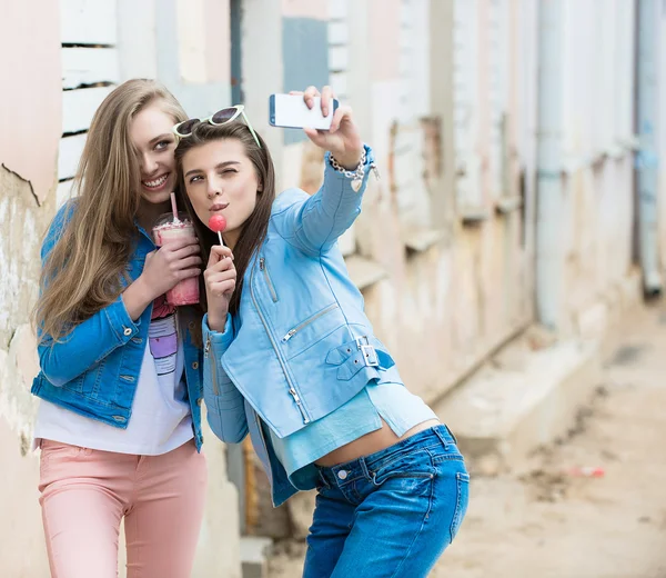 Novias Hipster tomando una selfie en el contexto urbano de la ciudad - Concepto de amistad y diversión con nuevas tendencias y tecnología - Mejores amigos eternizando el momento con un teléfono inteligente moderno — Foto de Stock
