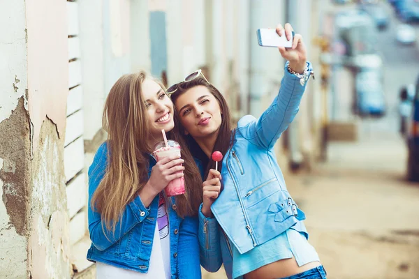 Novias Hipster tomando una selfie en el contexto urbano de la ciudad - Concepto de amistad y diversión con nuevas tendencias y tecnología - Mejores amigos eternizando el momento con un teléfono inteligente moderno —  Fotos de Stock