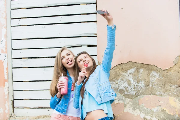 Hippi kız arkadaşlarım an modern smartphone ile eternalizing bir selfie - dostluk ve yeni trendler ve teknoloji ile eğlenceli kavramı - kentsel şehir bağlamda alarak