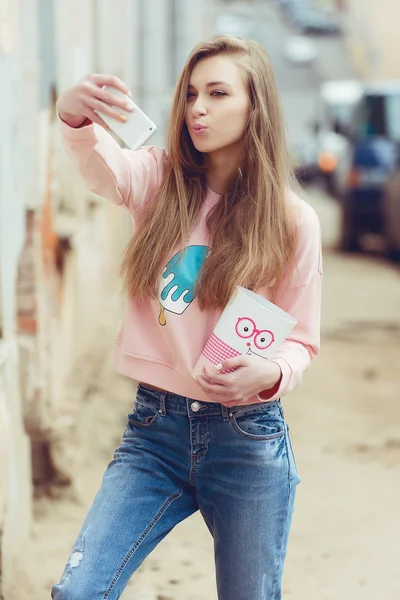 Hipster Mode Mädchen urbanen Stil. Süßigkeiten in der Hand auf Roller in der Stadt — Stockfoto