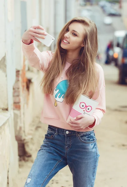 Hipster moda menina estilo urbano. Doces em uma mão em scooter na cidade — Fotografia de Stock