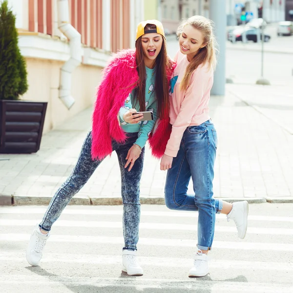 Novias Hipster tomando una selfie en el contexto urbano de la ciudad - Concepto de amistad y diversión con nuevas tendencias y tecnología - Mejores amigos eternizando el momento con un teléfono inteligente moderno —  Fotos de Stock