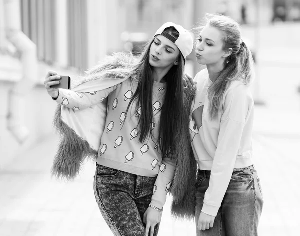 Novias Hipster tomando una selfie en el contexto urbano de la ciudad - Concepto de amistad y diversión con nuevas tendencias y tecnología - Mejores amigos eternizando el momento con un teléfono inteligente moderno — Foto de Stock