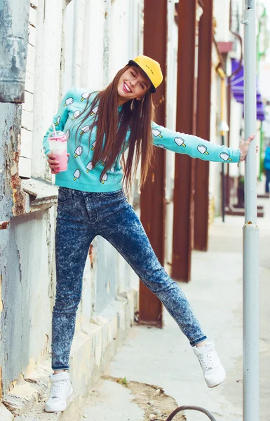 Sonriente chica hipster con taza de bebida caliente en la calle de la ciudad —  Fotos de Stock