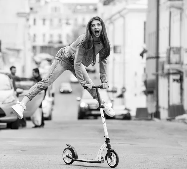 Chica en un monopatín en la ciudad —  Fotos de Stock