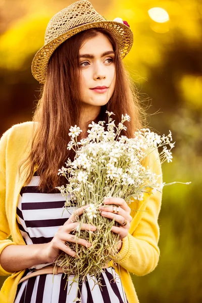 Хипстер моды девушка в соломенной шляпе сохранить красоту цветы — стоковое фото