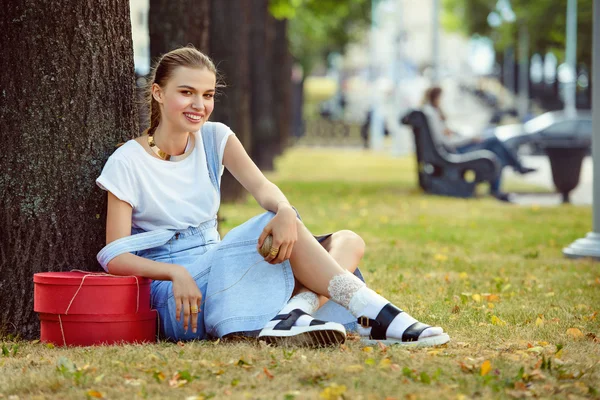 Dziewczyna leży na trawie w pończochy modne ubrania sukienkę — Zdjęcie stockowe