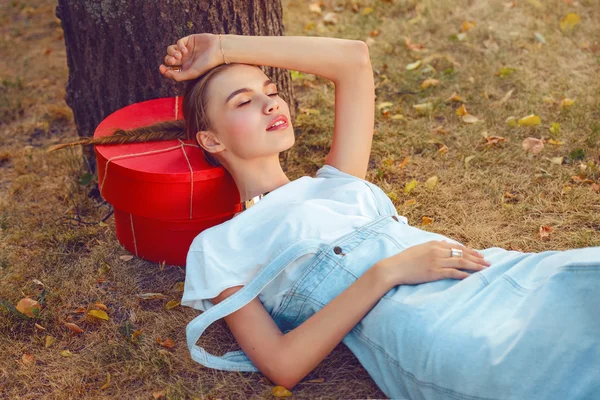 Holka leží na trávě v módní oblečení punčochy letní šaty — Stock fotografie