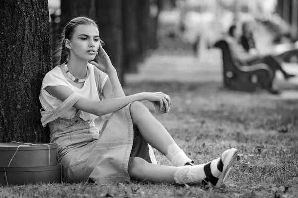 Ragazza si trova su un'erba in abiti alla moda calze un sundress — Foto Stock