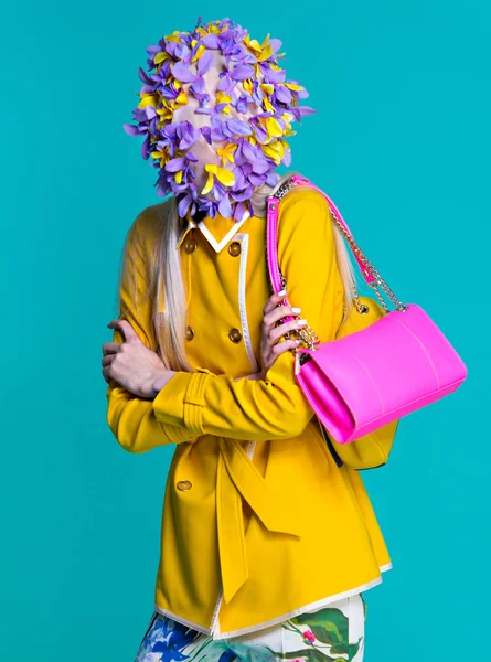 Modella in cappotto giallo e accessori d'arte in posa in studio su sfondo blu — Foto Stock