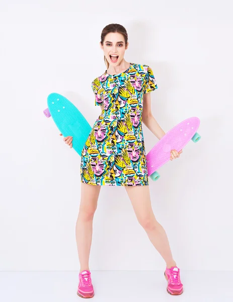 Modelo de moda sexy moda en vestido colorido con adorno brillante promover longboards en el estudio —  Fotos de Stock
