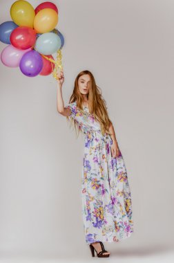 renkli balonlar tutan elbiseli sarışın saçlı güzel model kadın moda stüdyo fotoğrafı