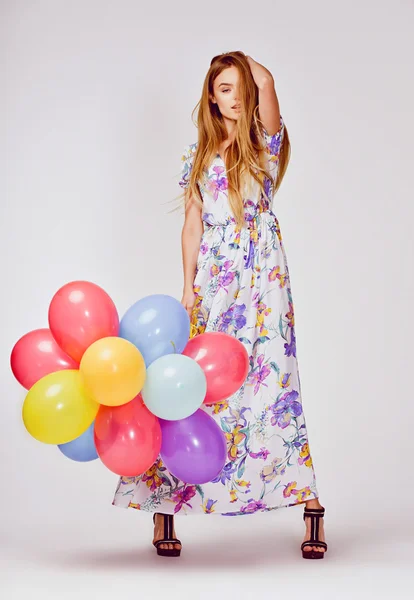 Foto del estudio de moda de la hermosa modelo de mujer con el pelo rubio en el vestido de celebración de globos de colores — Foto de Stock