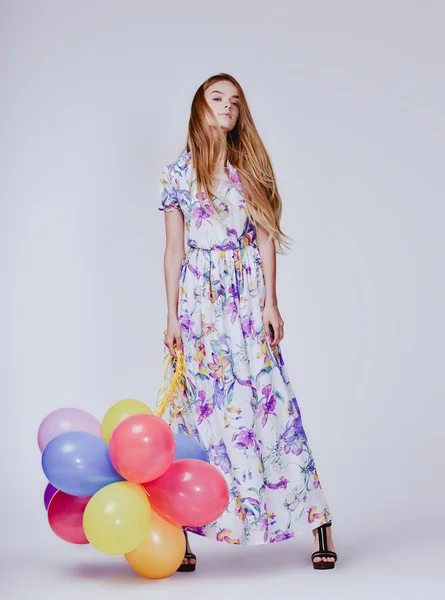 Foto studio di moda di bella donna modello con i capelli biondi in abito tenendo palloncini colorati — Foto Stock