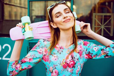 Bir kaykay üzerinde şehir sokak ile poz güzel ve moda kadın