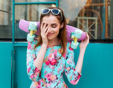 Bir kaykay üzerinde şehir sokak ile poz güzel ve moda kadın