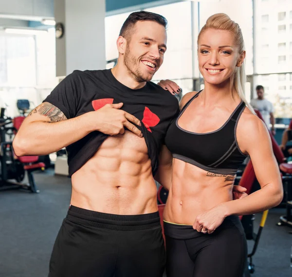 Mujer del gimnasio haciendo ejercicio con su entrenador personal — Foto de Stock