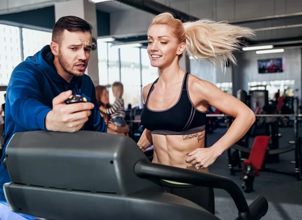 Ginástica mulher exercitando com seu personal trainer — Fotografia de Stock