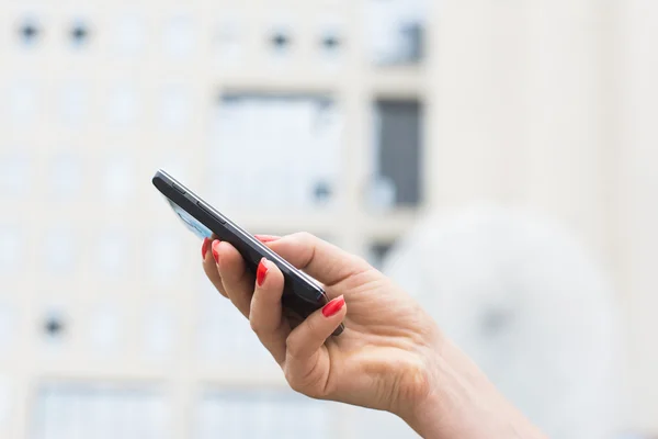 Frau hält Smartphone in der Hand — Stockfoto