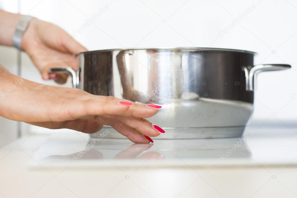 Woman using modern digital stove