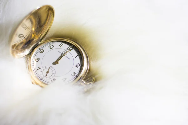 Golden watch set on twelve o'clock in white fur — Stock Photo, Image