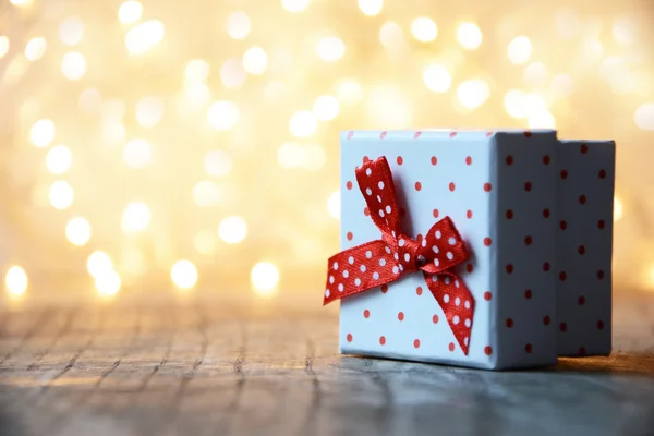 Caja de regalo blanca con puntos rojos y fondo bokeh —  Fotos de Stock
