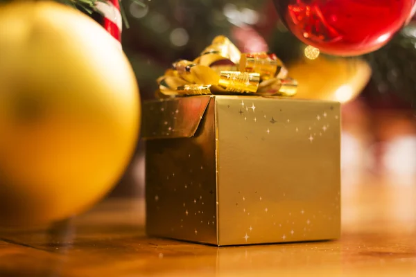 Ağacın altında altın hediye kutusu — Stok fotoğraf