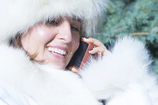 Glad kvinna på telefonen i vinterpäls — Stockfoto