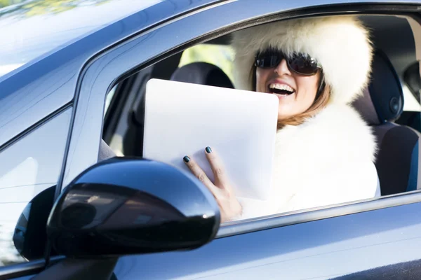 Femme en manteau blanc avec ipad rire — Photo