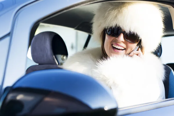 Femme en manteau blanc au téléphone souriant — Photo