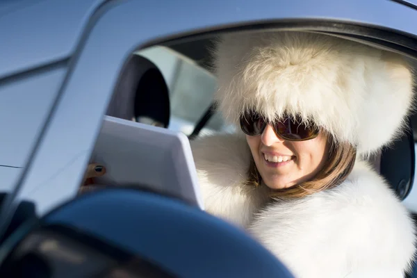 Femme en manteau blanc avec ipad rire — Photo