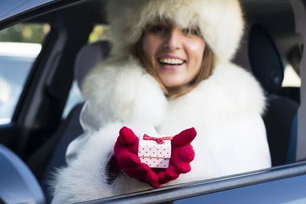 Femme souriante donnant une boîte cadeau blanche avec des points rouges portant rouge — Photo