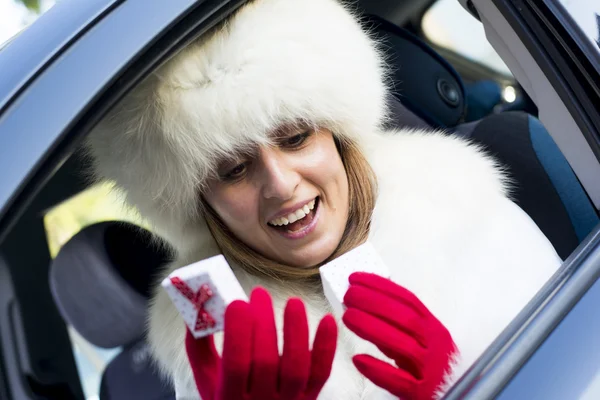 Femme souriante ouvrant une boîte cadeau blanche à pois rouges portant du rouge — Photo