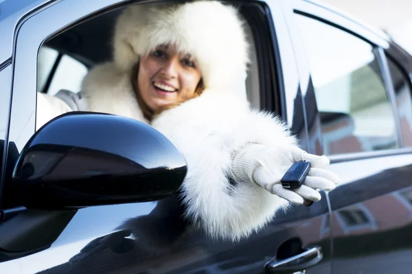 Усміхнена жінка з ключем від машини — стокове фото