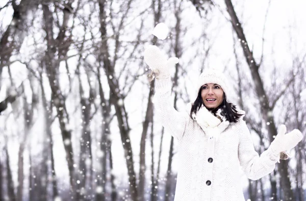 Vacker kvinna kastar snöboll — Stockfoto