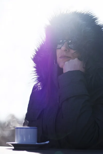 Donna in giacca con cappuccio bere caffè caldo all'aperto — Foto Stock