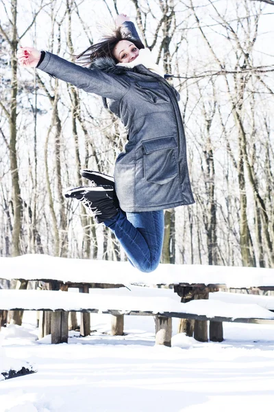 Mulher feliz pulando no inverno na floresta — Fotografia de Stock