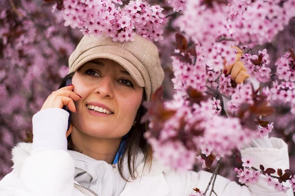 Mladá žena s kloboukem na telefonu v přírodě — Stock fotografie