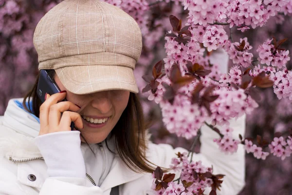 Mladá žena s kloboukem na telefonu v přírodě — Stock fotografie