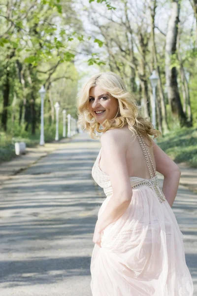 Mujer rubia en vestido de noche corriendo — Foto de Stock