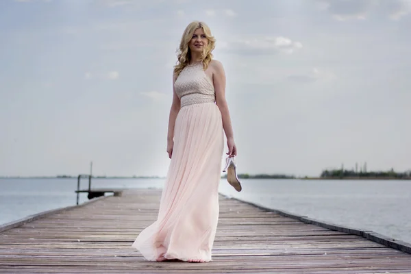 Блондинка в вечірній сукні на озері — стокове фото