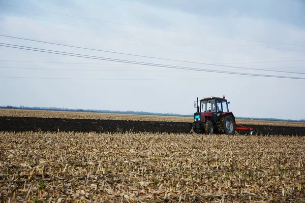 Tractor in the field in the middle of tillage — Stock Photo, Image