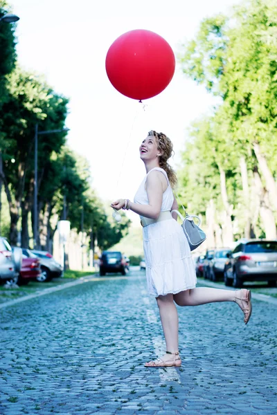 Chica rubia rizada con gran globo rojo — Foto de Stock