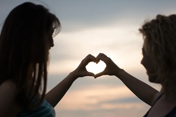 Two girls making heart shape