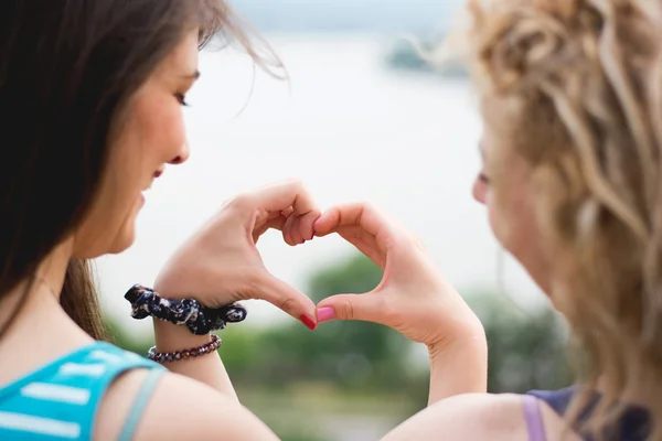 Two girls making heart shape — Stok fotoğraf