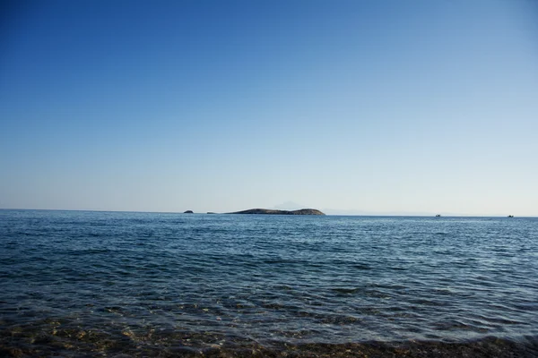 Błękitne wody z wyspą w środku morza — Zdjęcie stockowe