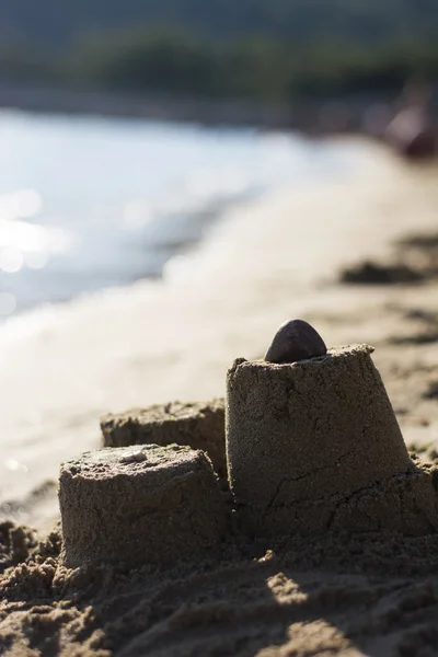 Castillo de arena en la playa al atardecer — Foto de Stock