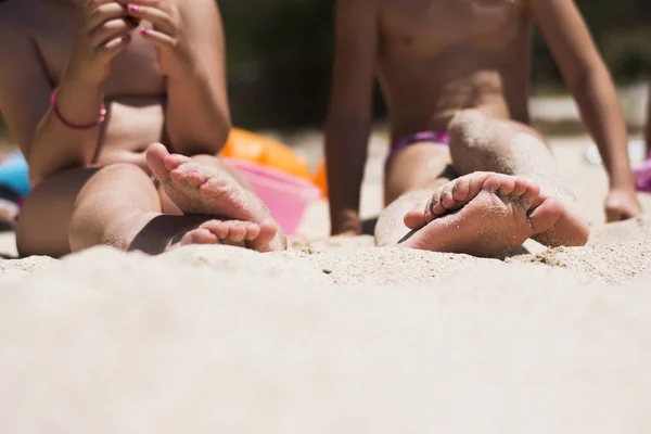 Pés de crianças na areia na praia — Fotografia de Stock